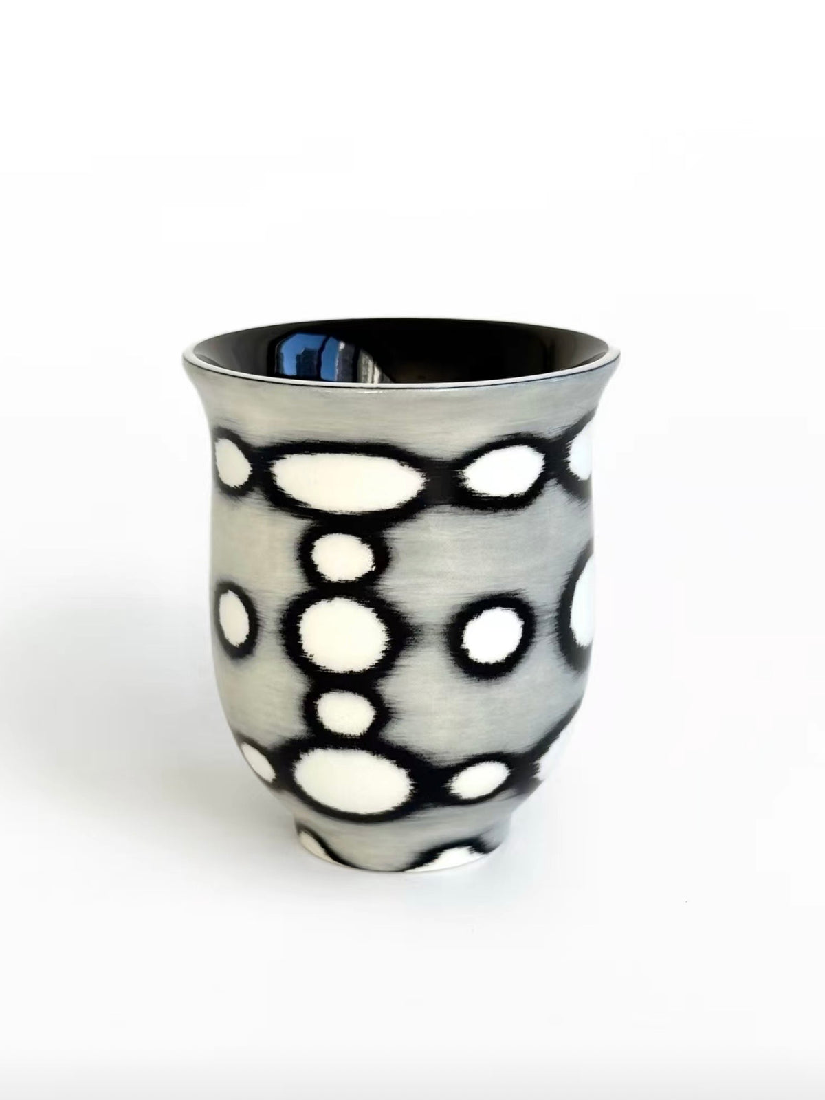 White ceramic tea cup with black circle outline pattern, flared shape, TalkFun collection